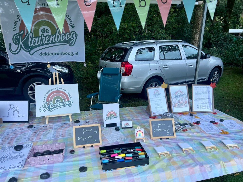 Tafel vol creatieve coaching activiteiten van Kinderpraktijk De Kleurenboog zoals stenen beschilderen (Blije Kei) en mini schildersezels