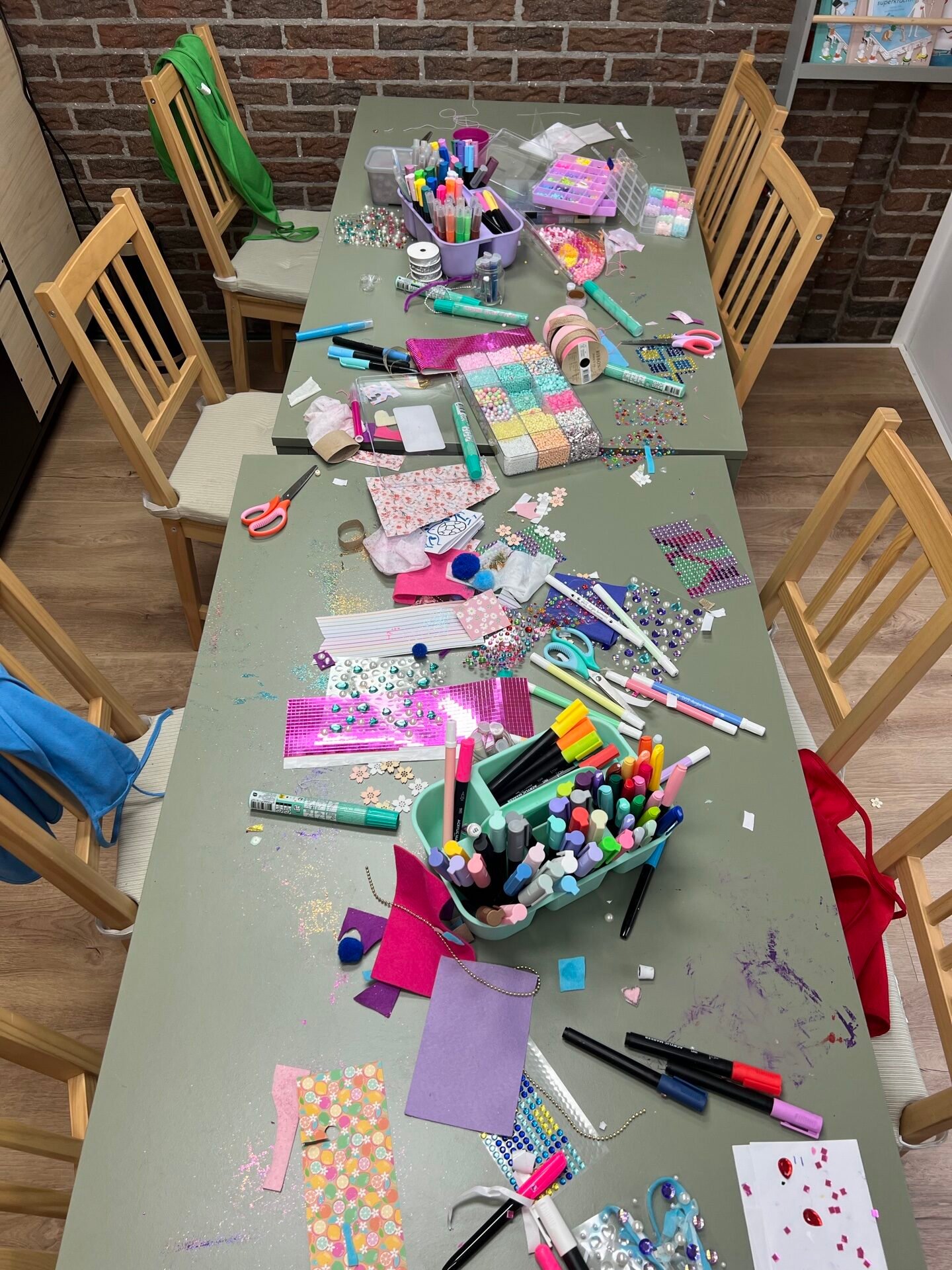 Creatief kinderfeestje na afloop – Kinderpraktijk De Kleurenboog Tafel vol vrolijke kunstwerken na een kinderfeestje bij De Kleurenboog